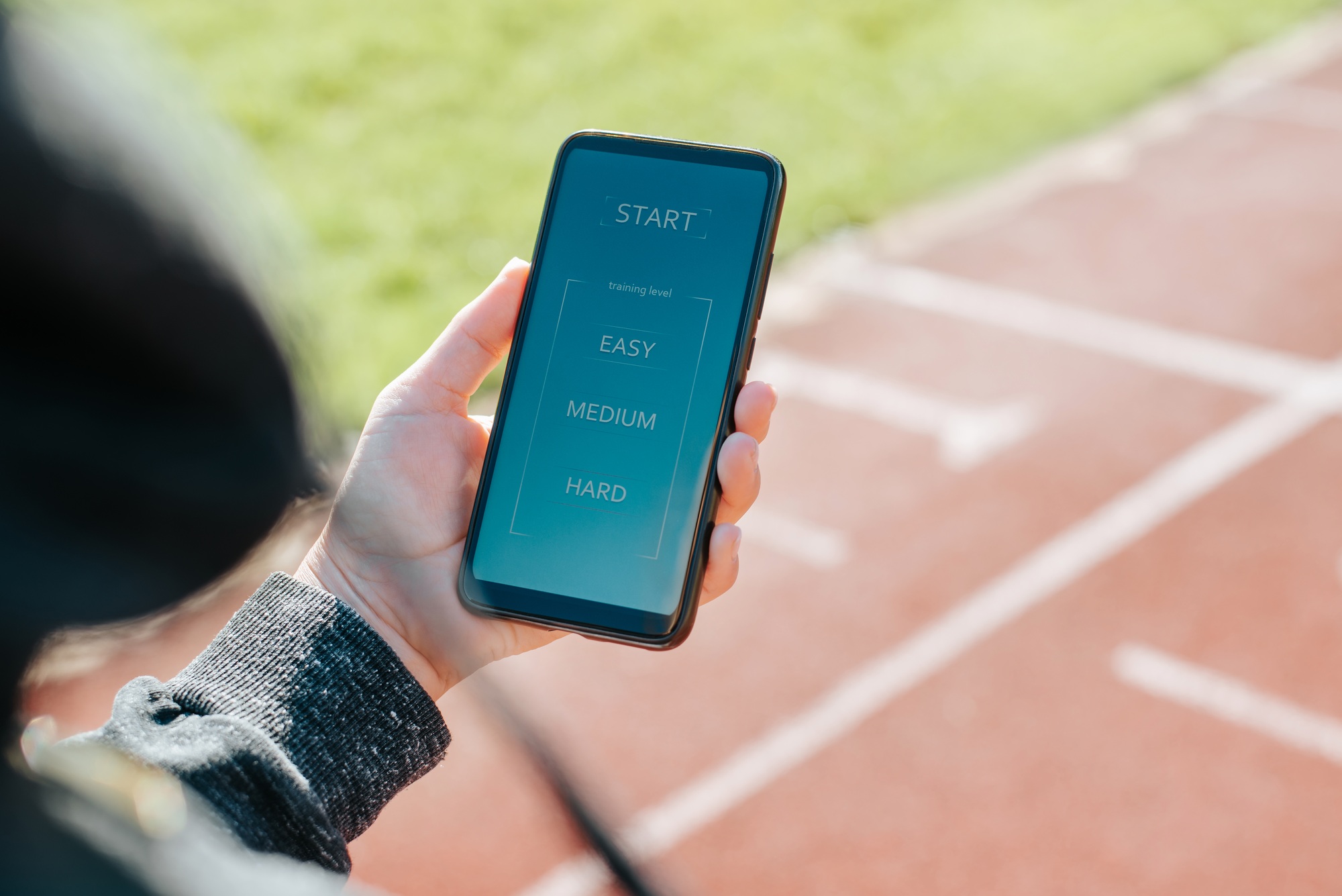 Application of training program with difficulty levels on smartphone. Close-up woman athlete